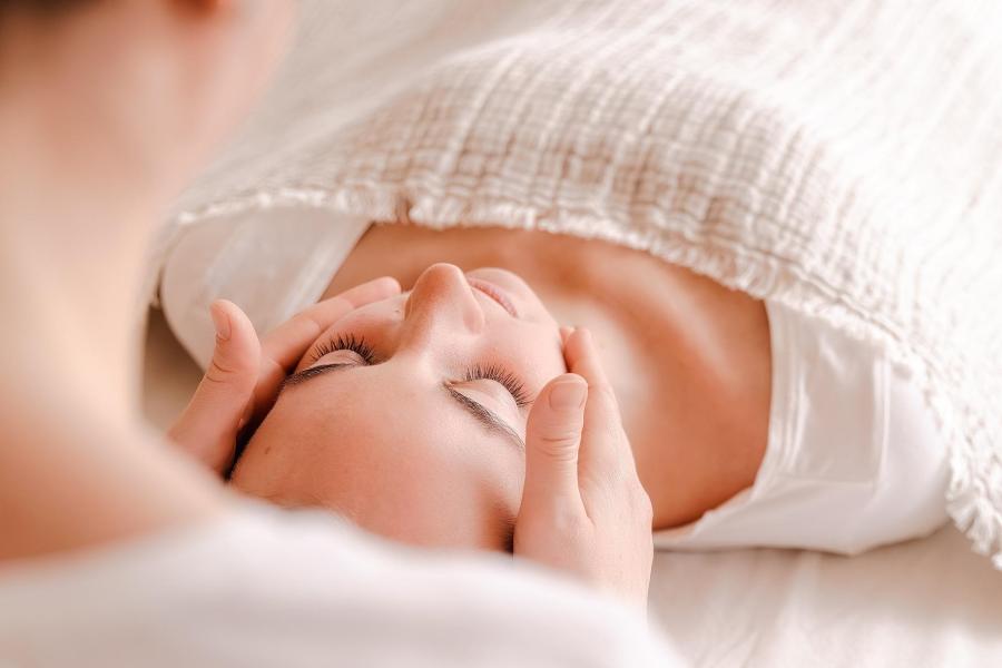 woman receiving head, facial massage or Reiki